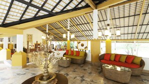 A spacious lobby with a high ceiling, wicker furniture, and a decorative table. - Amaya Lake Dambulla (Kandalama)