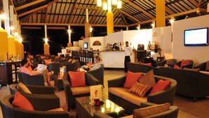 A spacious lounge area with wicker furniture and a bar area in the background. - Amaya Lake Dambulla (Kandalama)