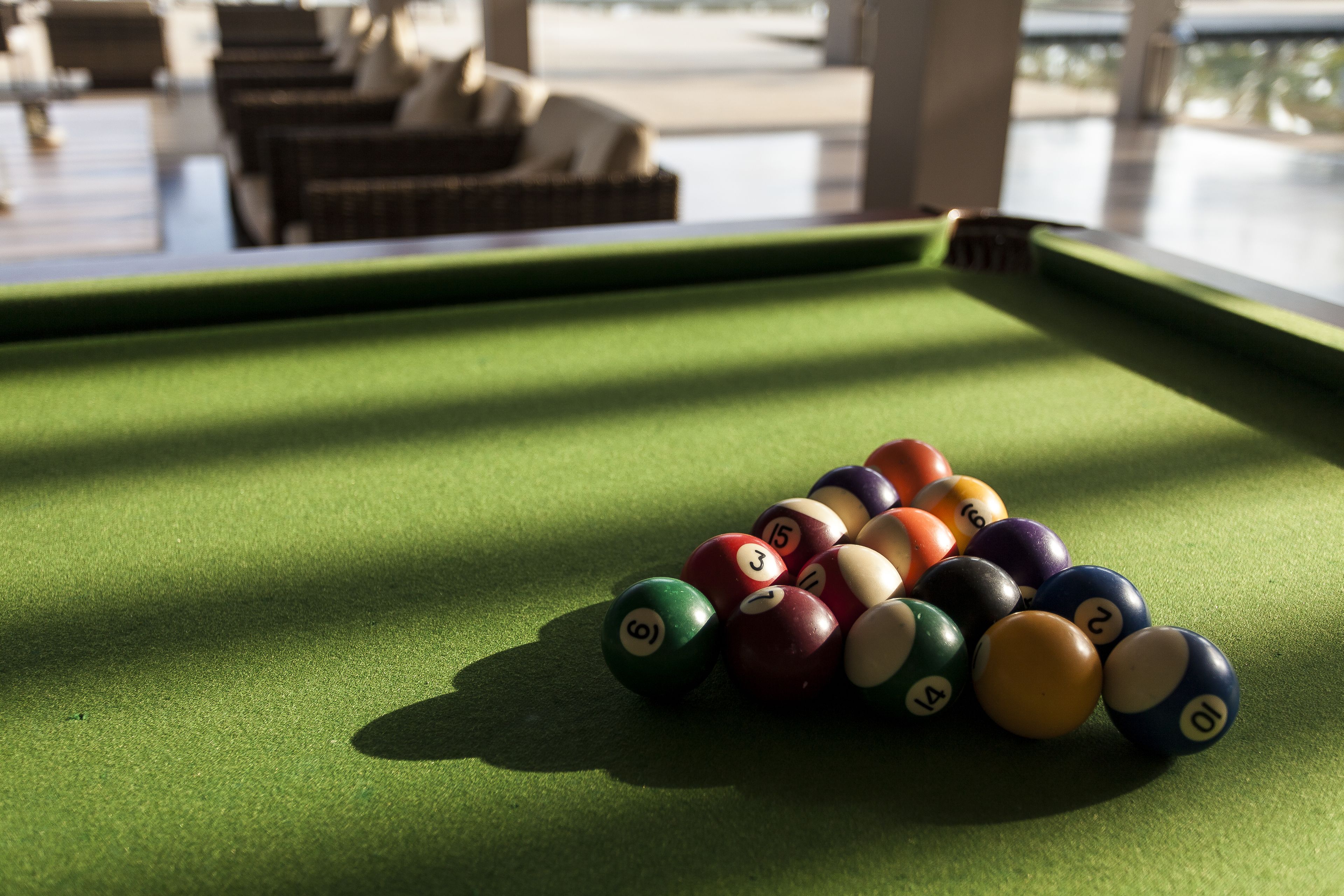 A pool table with a green felt surface and numbered billiard balls.