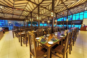 A spacious restaurant with high ceilings and large windows, offering a view of the outdoors. Tables are neatly arranged with chairs, and the interior is well-lit. - Citrus Hikkaduwa (Hikkaduwa)