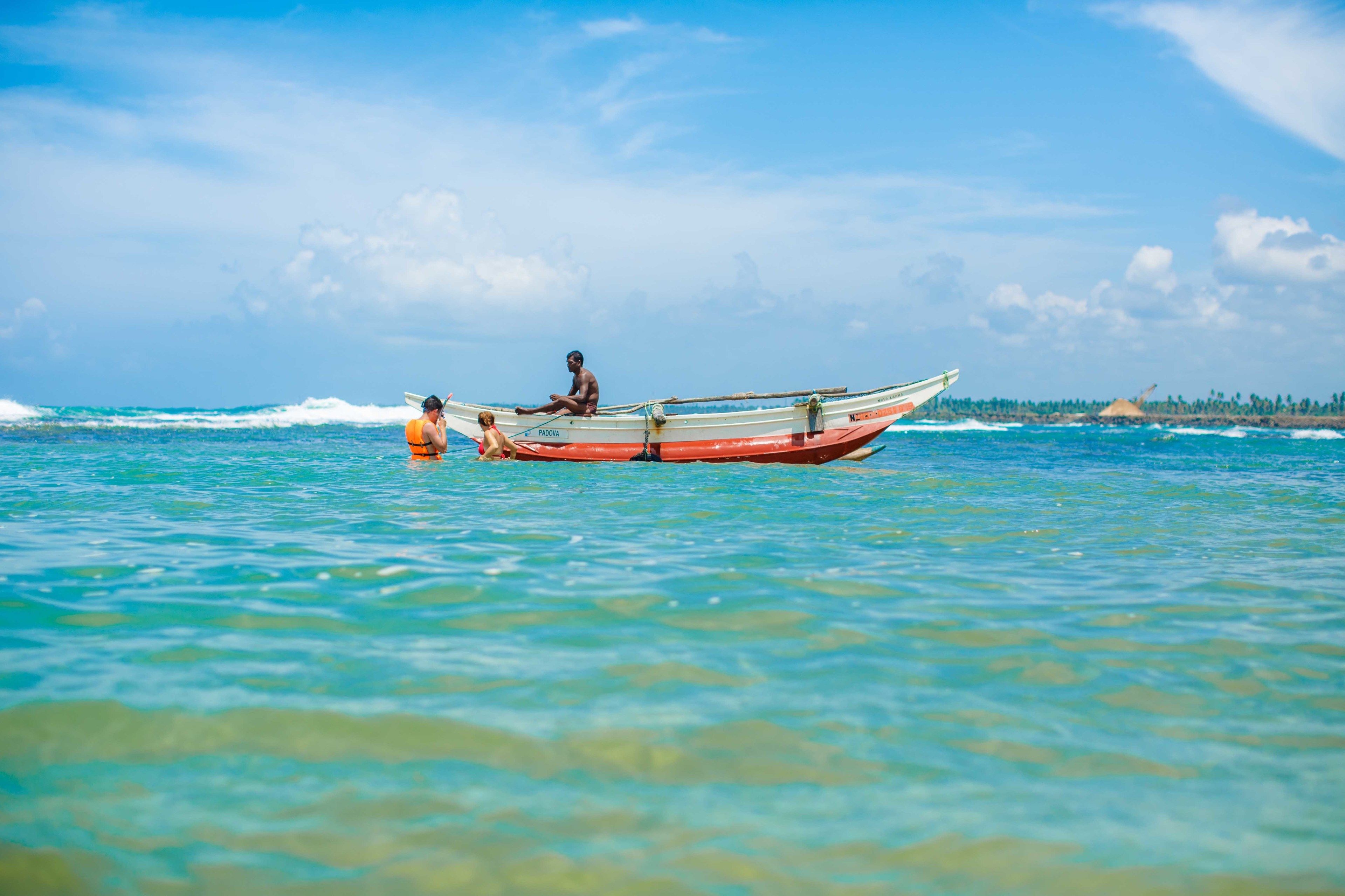 A boat on calm turquoise water with a clear sky.