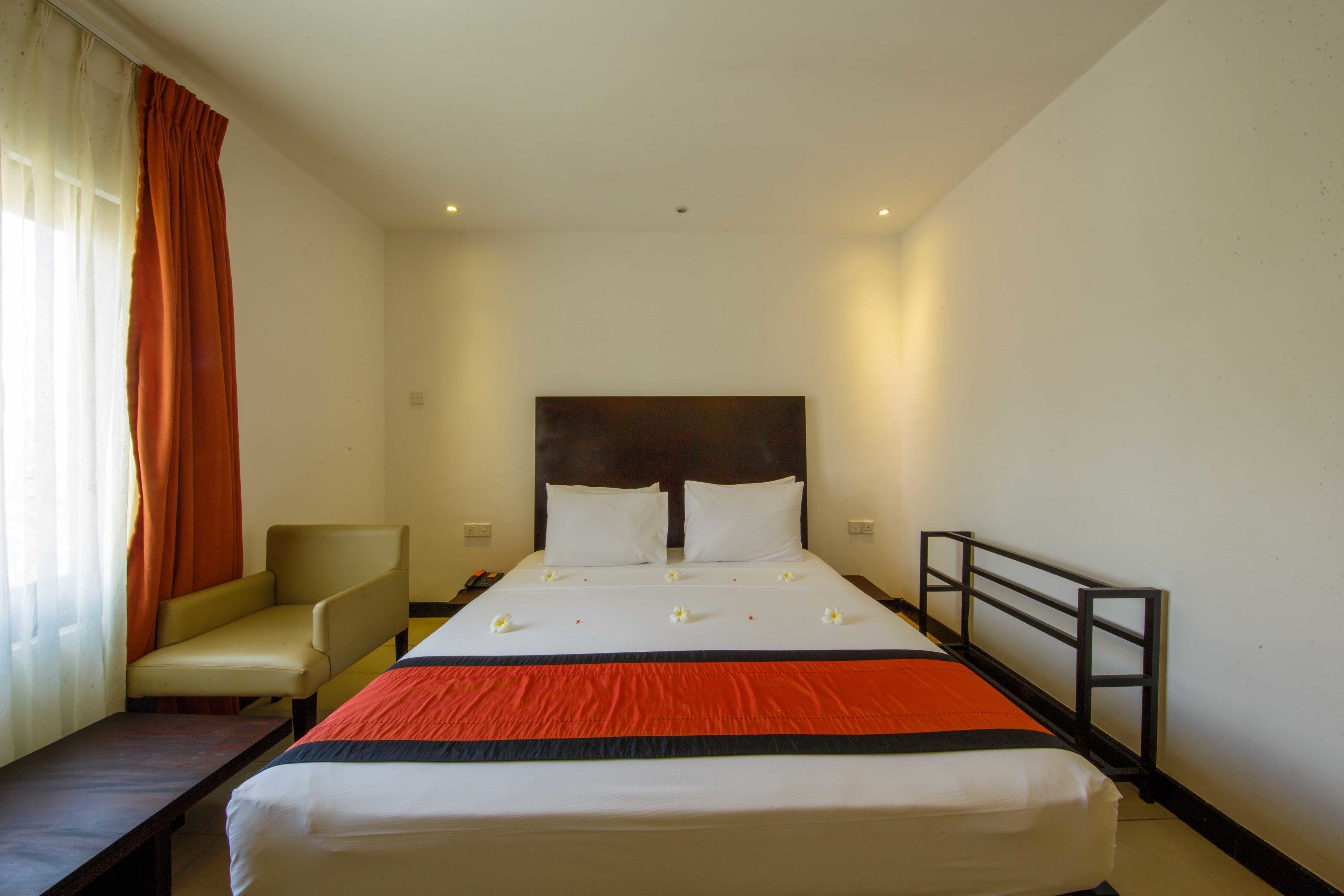 A hotel room with a bed, a chair, and a desk.