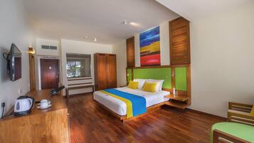 A hotel room with a bed, wooden desk, and a television.