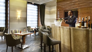 A bar area with a bartender, bar counter, and seating arrangement.