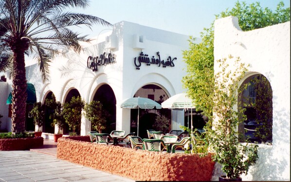 A building with arches and outdoor seating. - Marbella Resort Sharjah (Sharjah)