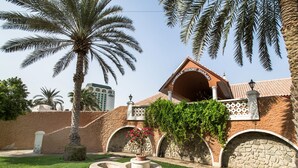 A resort with a stone facade, palm trees, and a sign reading "MARBELLA RESORT SHARJAH". - Marbella Resort Sharjah (Sharjah)
