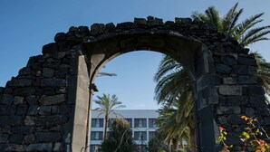 Una estructura de piedra arqueada con un camino que conduce a un edificio.