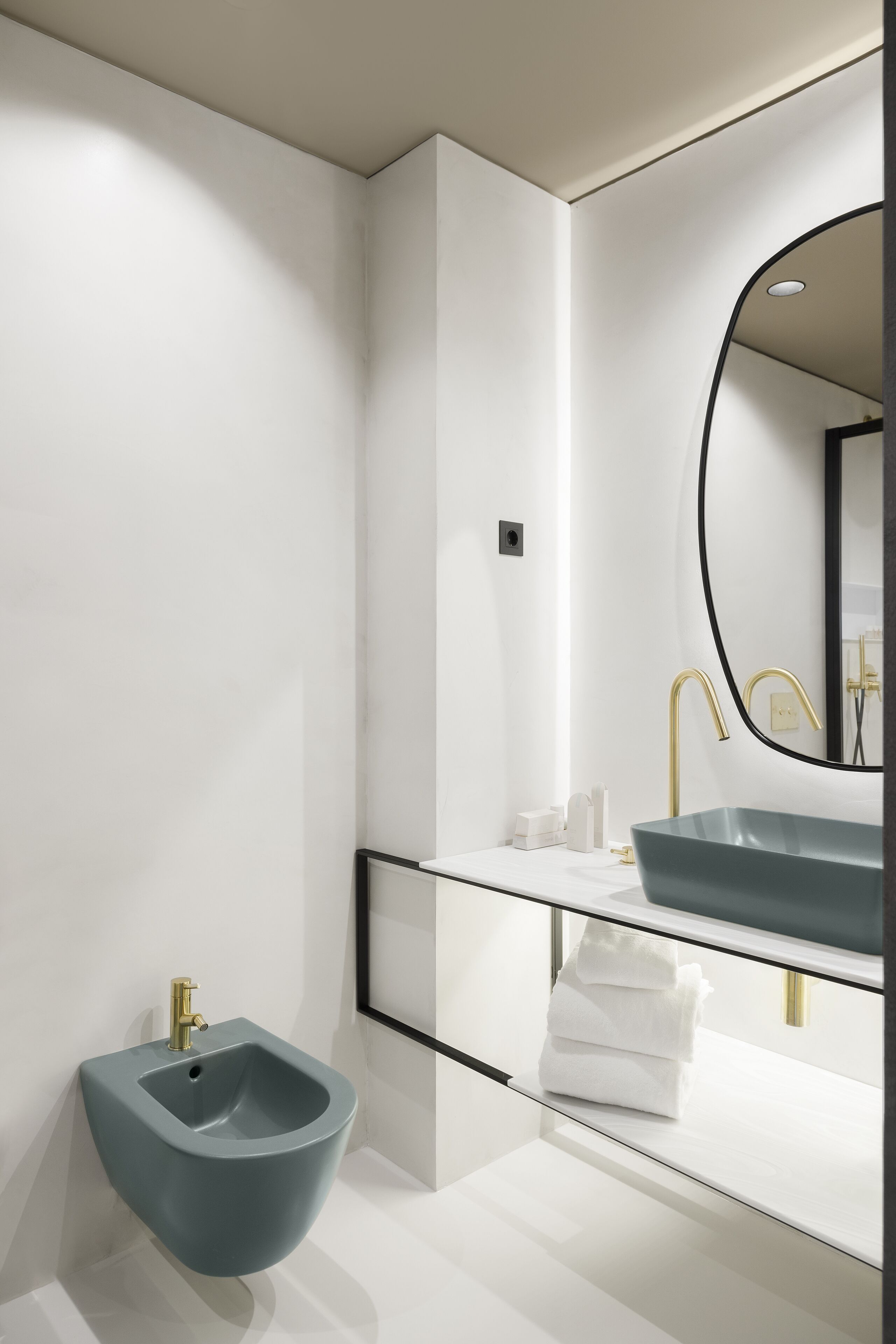 Ein modernes Badezimmer mit einer Bidet-Funktion, einem Waschbecken und einem Spiegel.