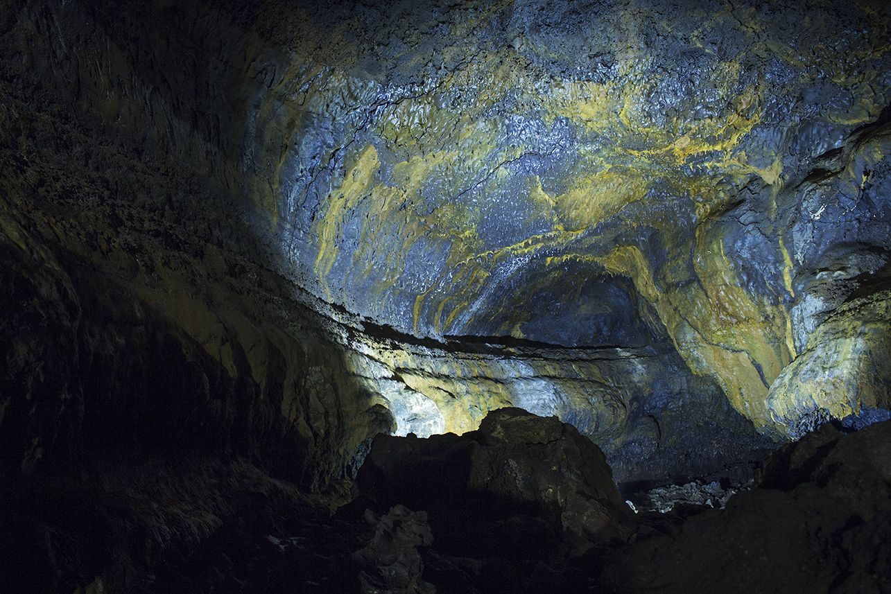 A cave with natural rock formations and a small opening at the top.