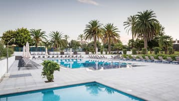 Piscine couverte, piscine extérieure, parasols de plage, chaises longues