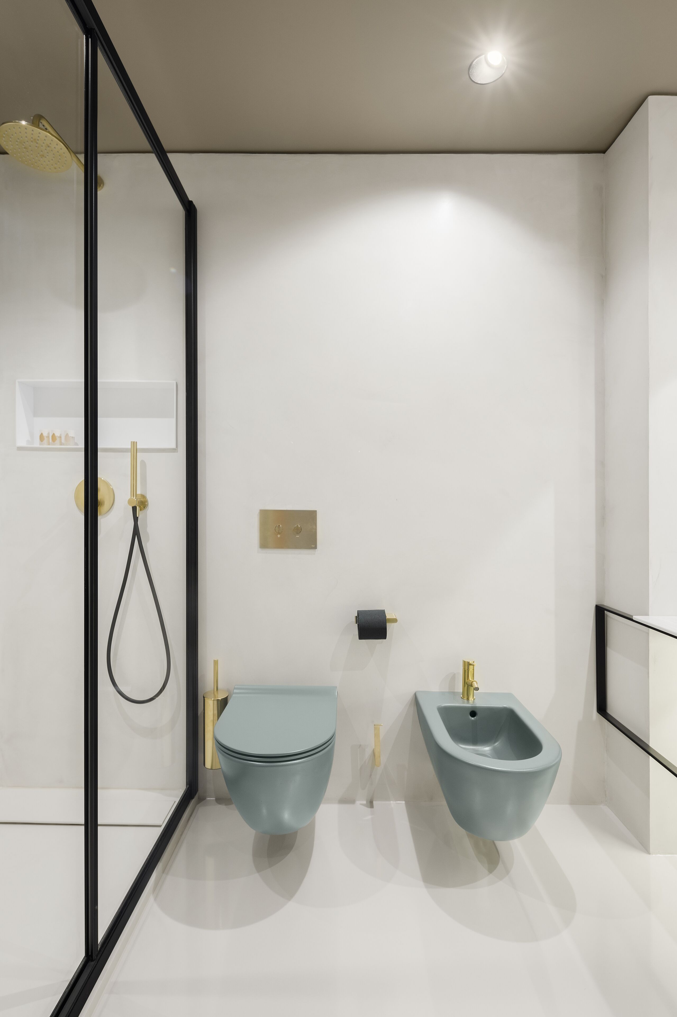 Een moderne badkamer met een douchecabine van glas, een toilet en een douchetoilet.