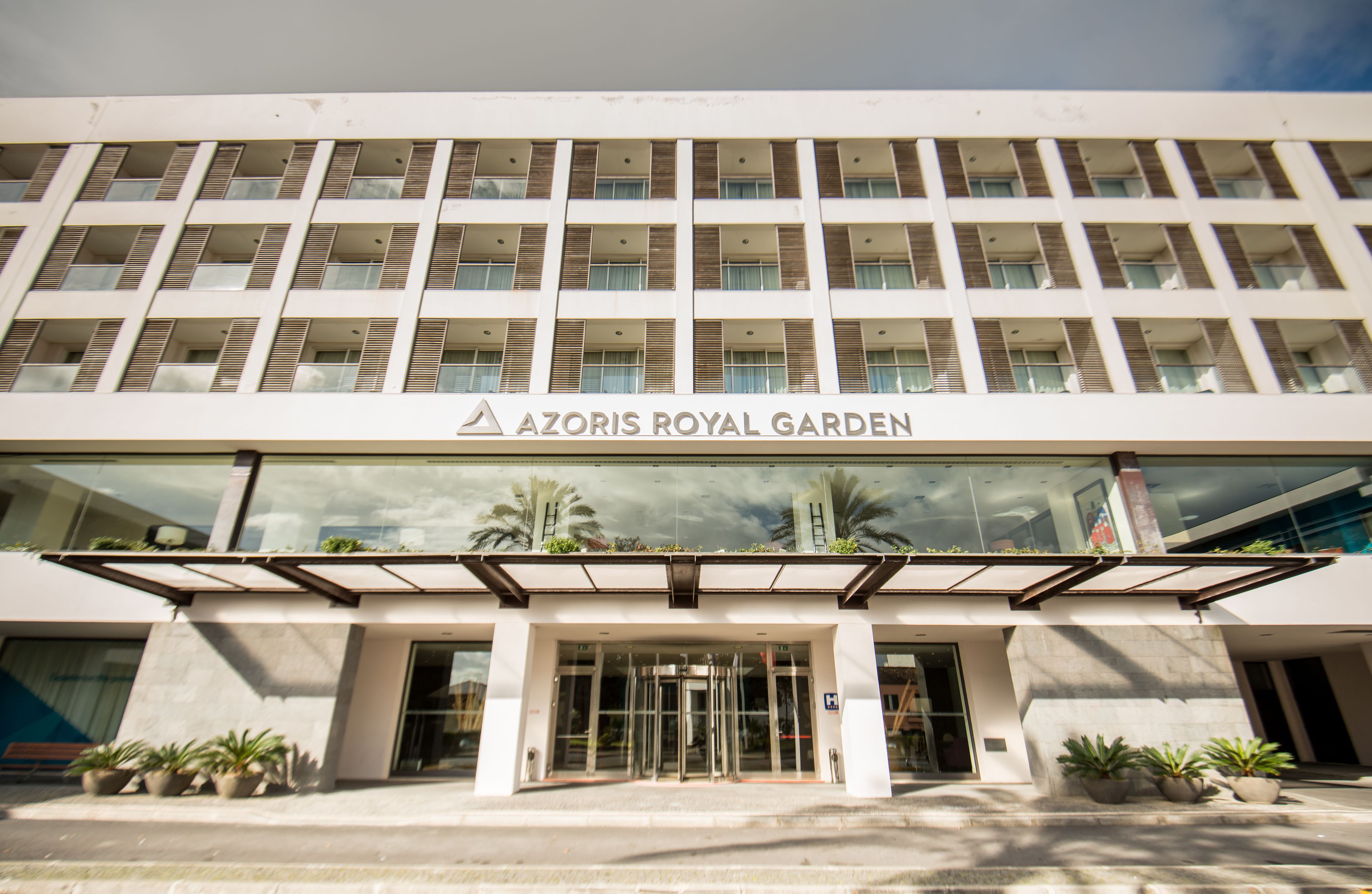 Um edifício de vários andares com uma placa que diz 'AZORIS ROYAL GARDEN'.