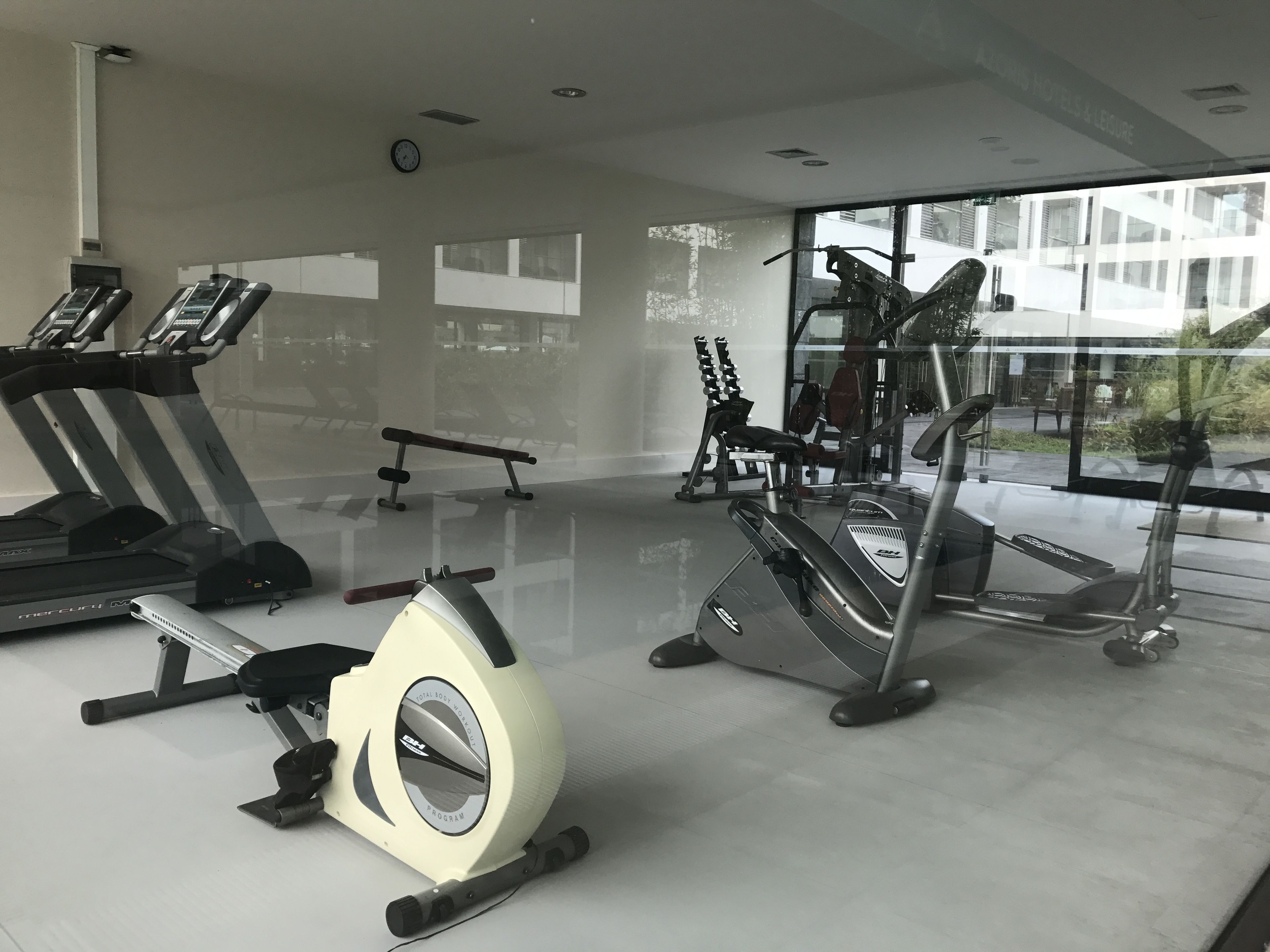 A modern gym with treadmills, an elliptical, and weight machines.
