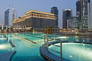 A swimming pool with a view of modern high-rise buildings in the background. - Rose Rayhaan by Rotana (Dubai)