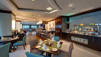A modern hotel dining area with a buffet and seating arrangements.