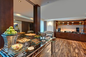 Zona de buffet con diversos alimentos y una estación de café.