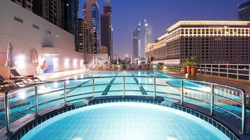 Una piscina cubierta con vistas a un paisaje urbano, rodeada de edificios modernos.