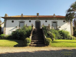 A building with a tiled roof, a central staircase, and a symmetrical facade with windows and decorative elements. - Casa de Juste - Lousada  (Lousada)