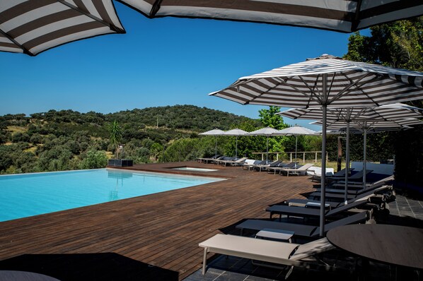 Una piscina al aire libre de temporada, sombrillas