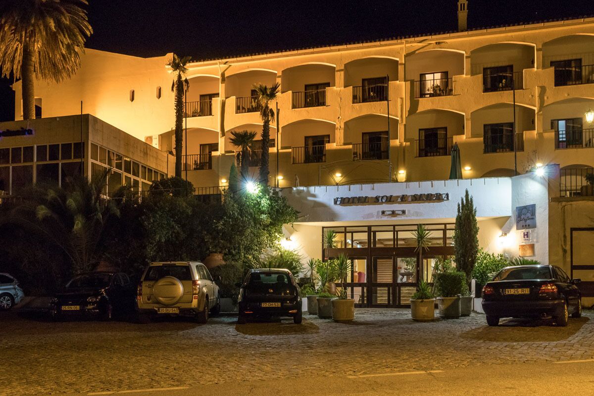 Un hotel con fachada blanca, varios balcones y un letrero que indica que es un hotel.