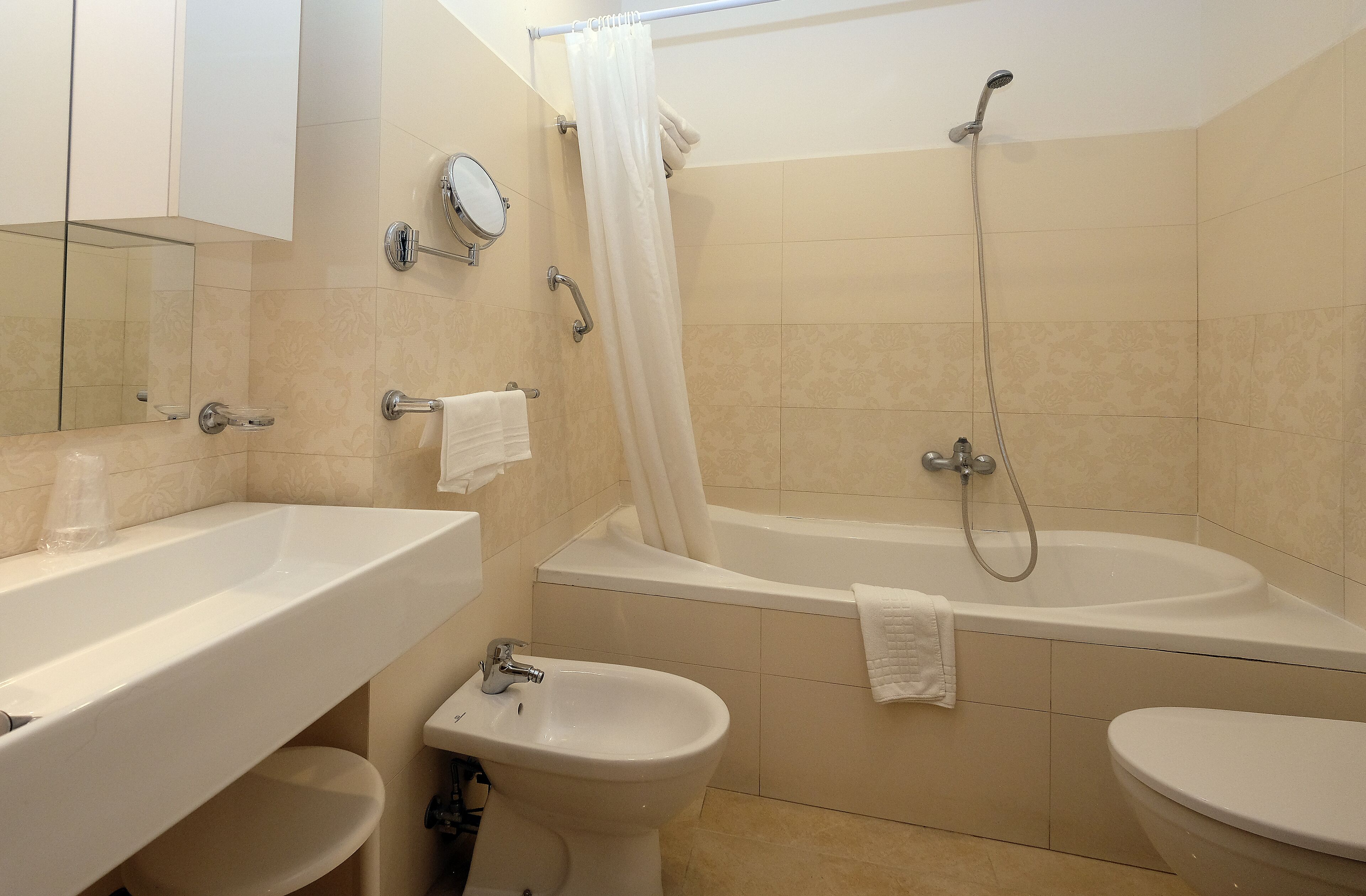 Un bagno con una vasca, una doccia, un lavandino e un bidet.
