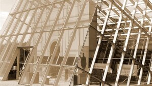Una gran estructura de vidrio transparente con un diseño geométrico, posiblemente un invernadero o una estufa fría.