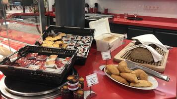 Ein Buffet mit verschiedenen Speisen, darunter Gebäck, Sandwiches und Beilagen.