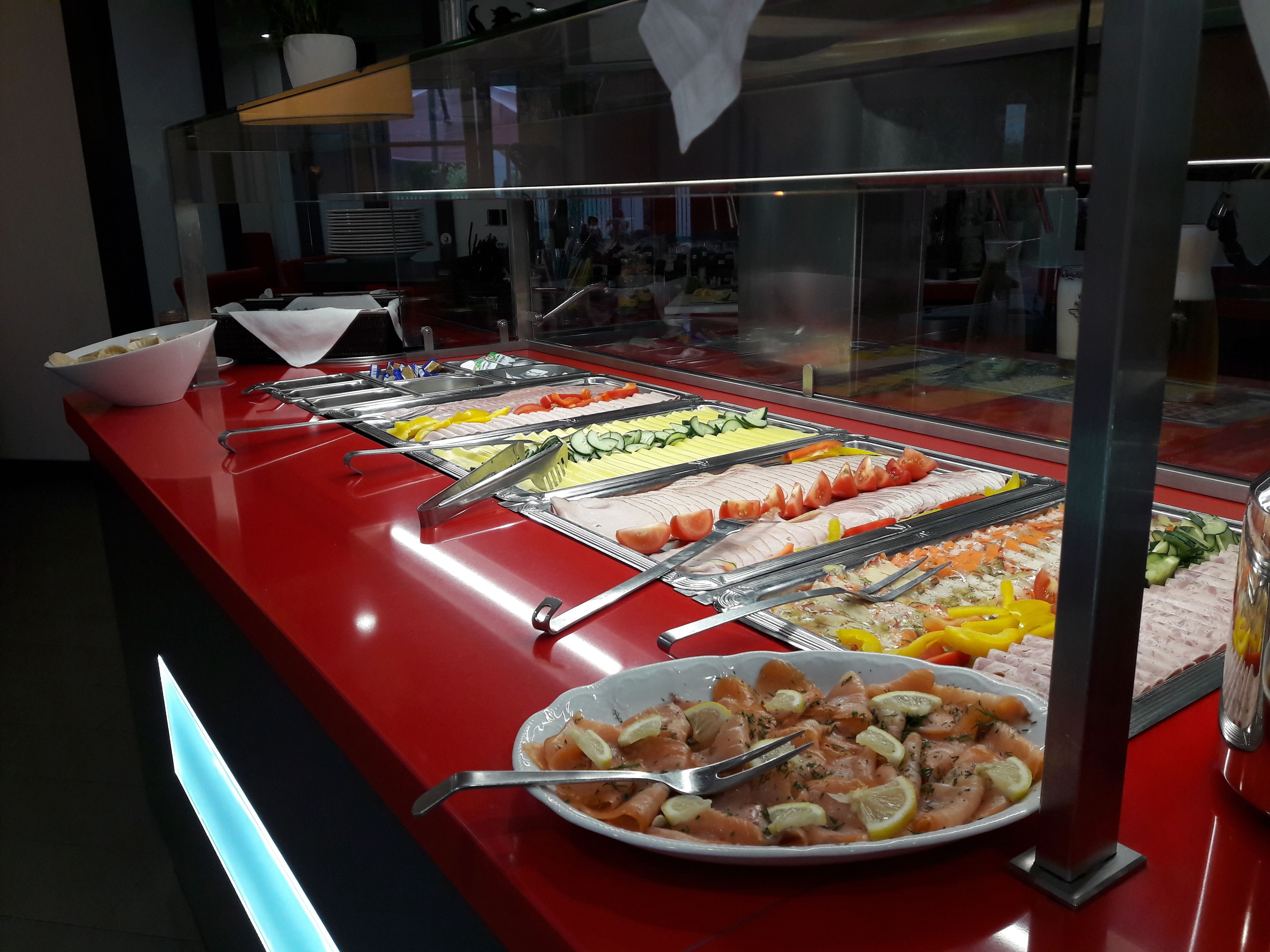 A buffet with various food items, including salmon, vegetables, and other dishes.