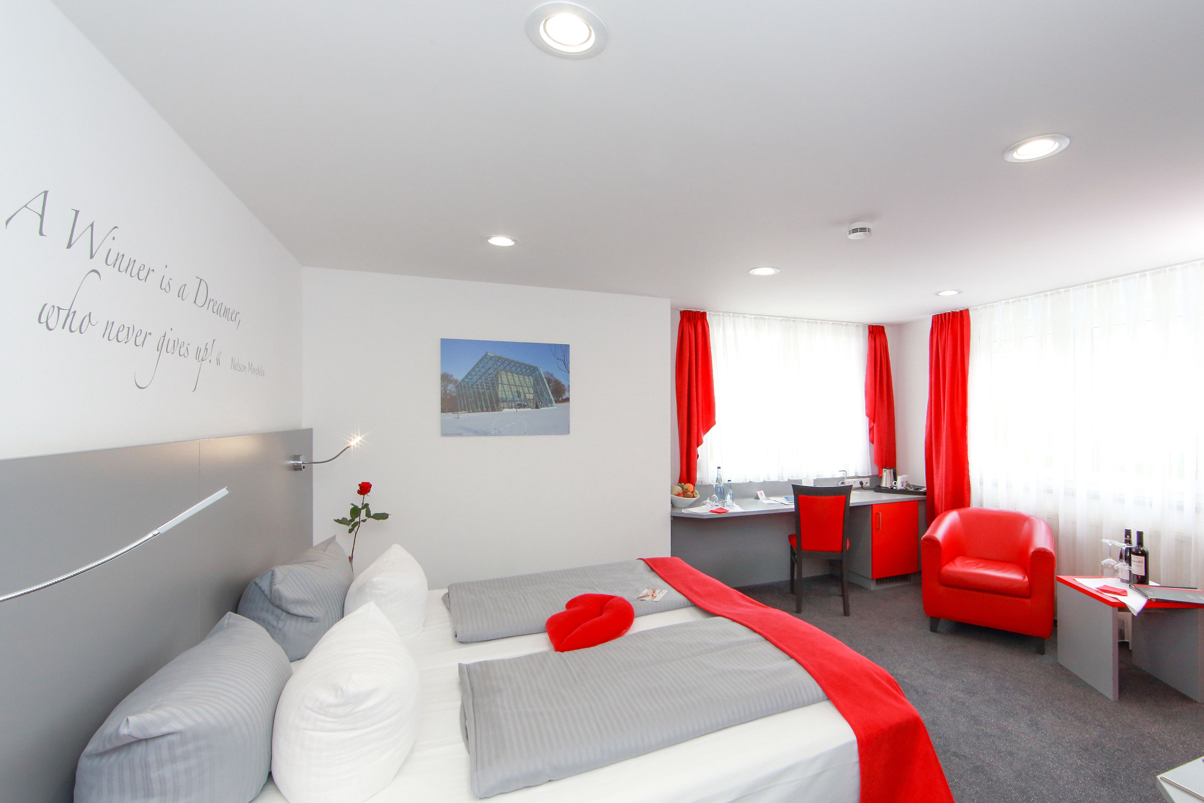 Ein Hotelzimmer mit Bett, Schreibtisch und Stuhl.
