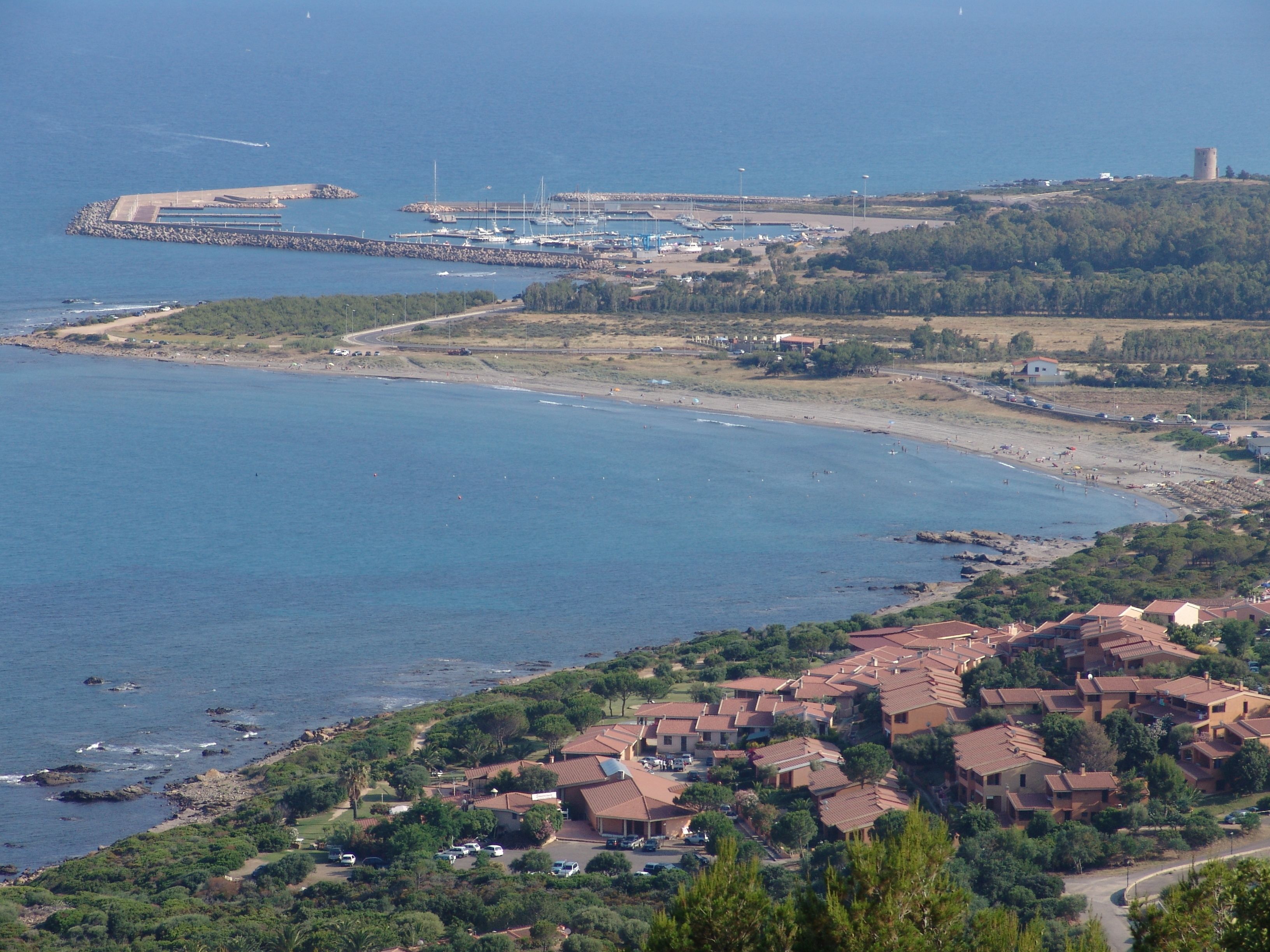 A coastal town with a marina, residential buildings, and a lighthouse.