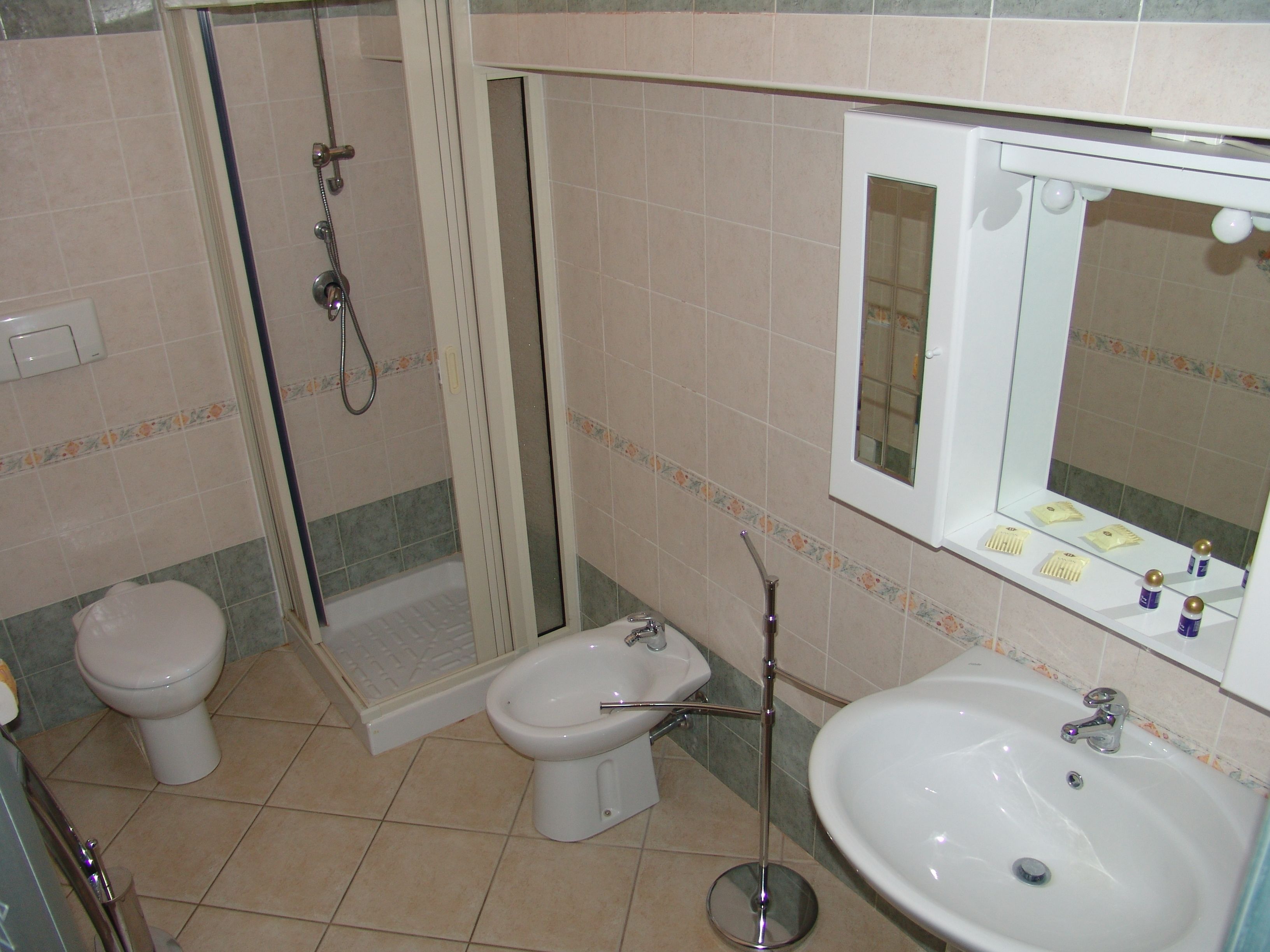 Ein Badezimmer mit Dusche, Toilette, Bidet und Waschbecken.