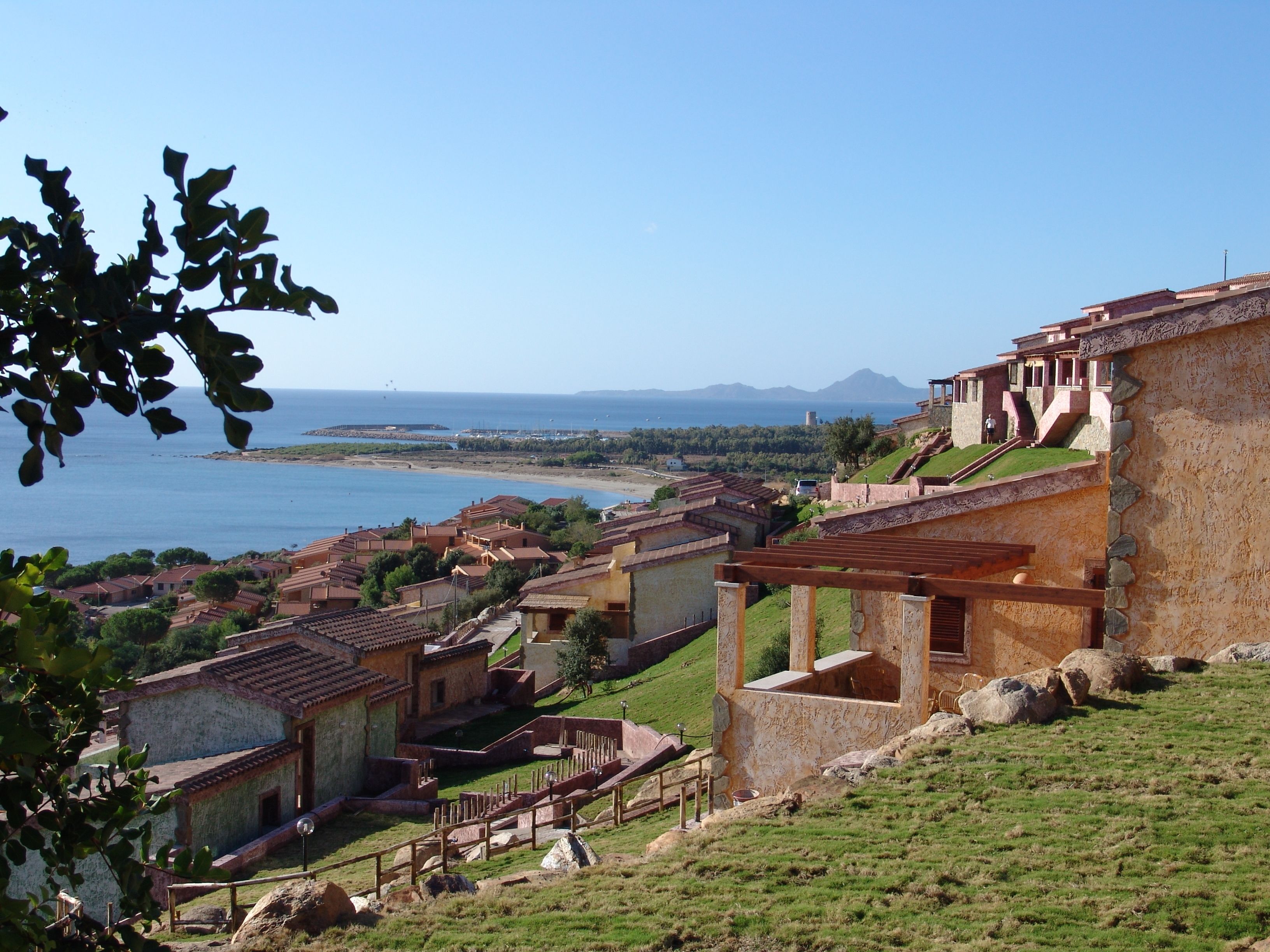 A coastal village with traditional architecture, terraced houses, and a view of the sea.