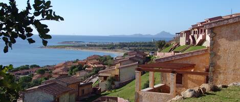 A coastal village with traditional architecture, terraced houses, and a view of the sea.