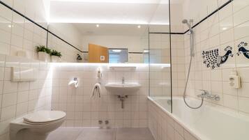 A modern bathroom with a toilet, sink, and shower.