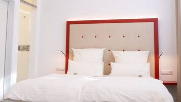 Una cama doble con cabecera roja en una habitación de hotel.