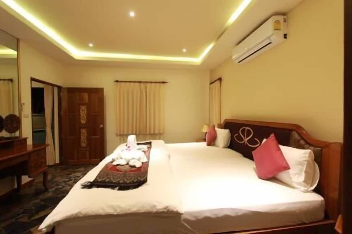 Quarto de hotel com cama, ar condicionado e espelho.