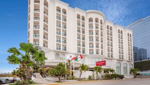 A multi-story hotel with a curved facade, balconies, and a flag. - Ramada Plaza by Wyndham Veracruz Boca del Rio (Boca del Río)