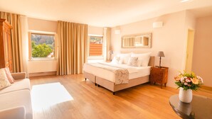 A spacious bedroom with a large bed, a sitting area, and a view of the outdoors. - Hotel Golden Key Prague (Prague)