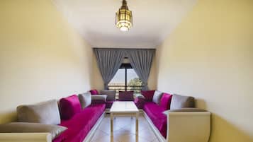 A room with a sofa set, a small table, and a cabinet.