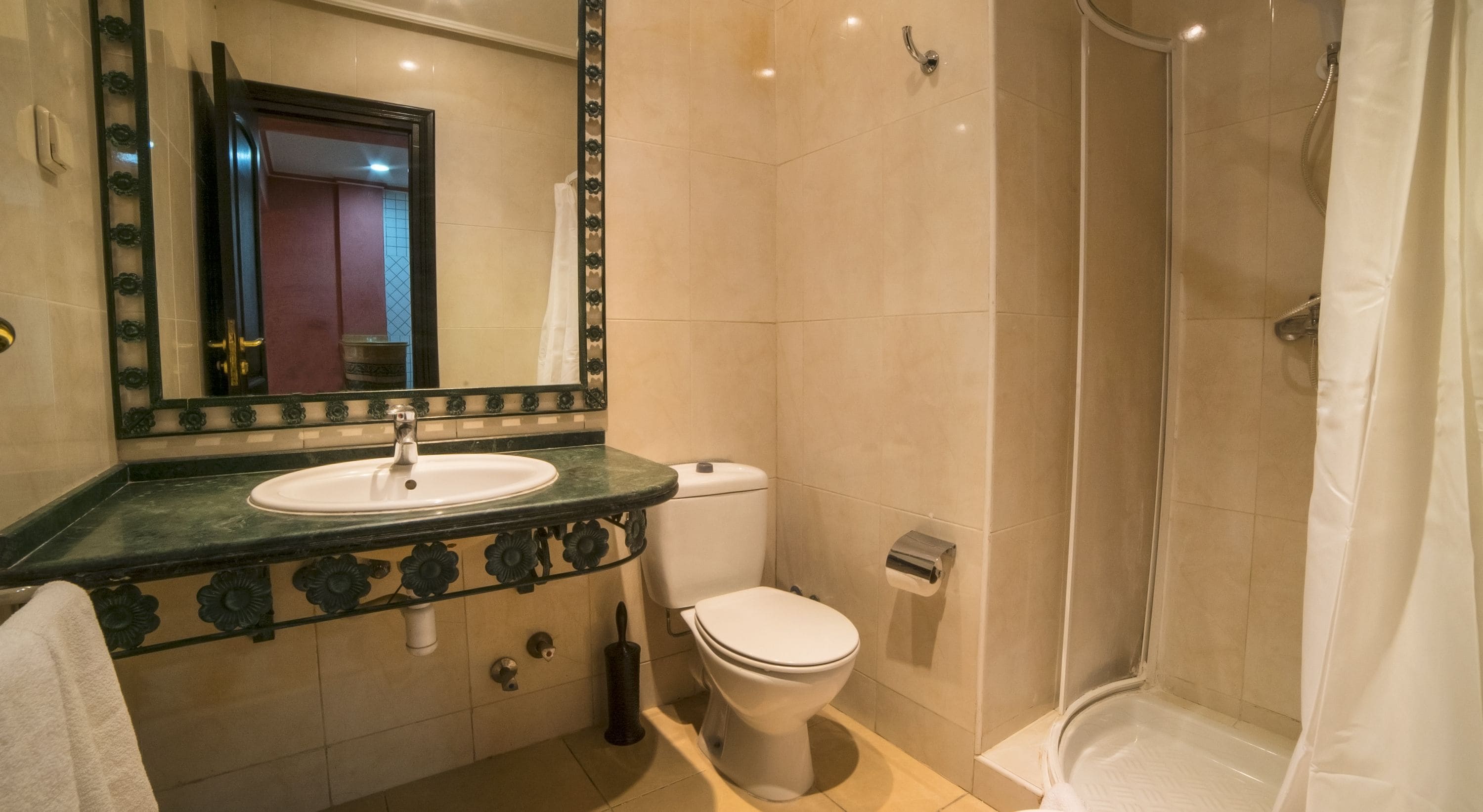 A bathroom with a sink, toilet, and shower.