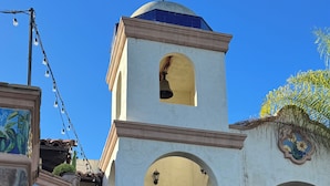 A building with a bell tower, arched windows, and a stone facade.