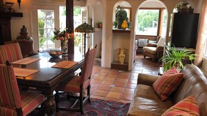 A traditional interior with a dining area, a sofa, and a television.