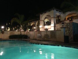 Una piscina al aire libre, sillones reclinables de piscina