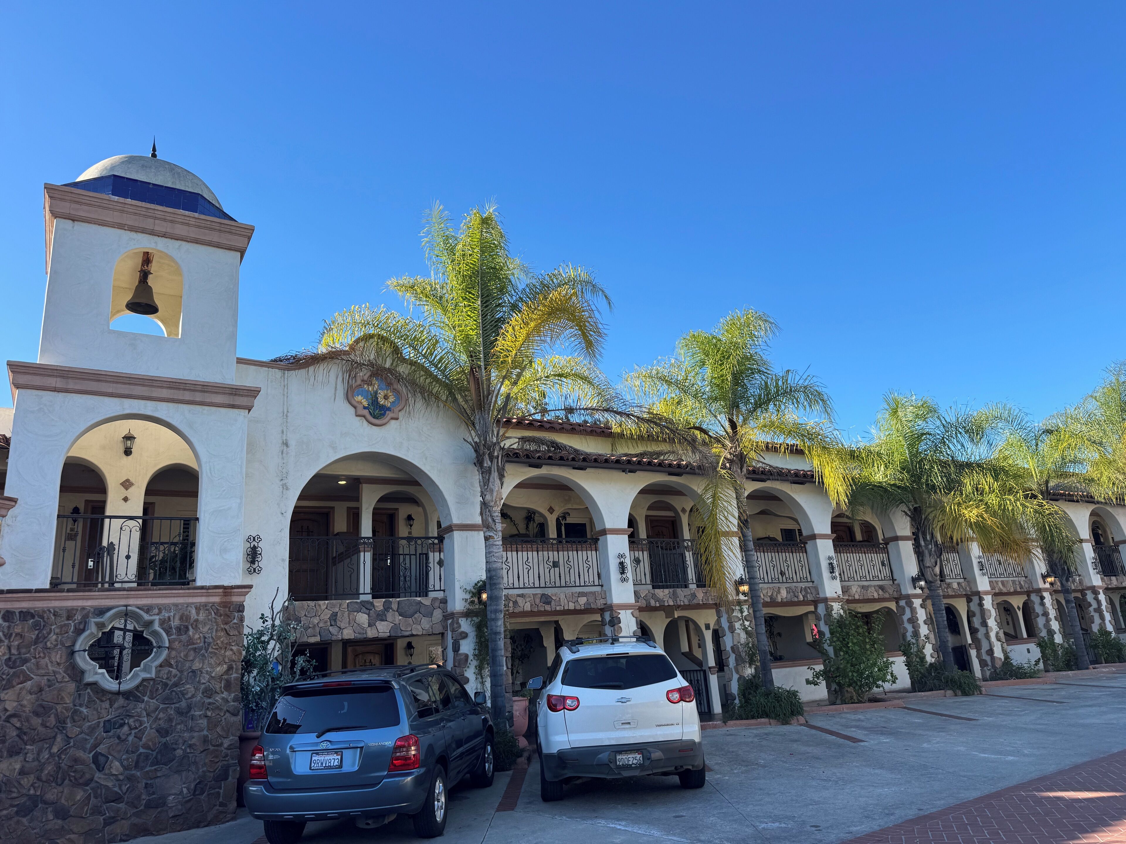 A building with a bell tower, arched windows, and a stone facade.