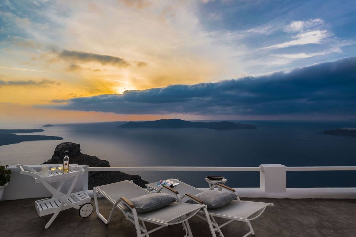 A terrace with white furniture, a bottle, and a magazine.