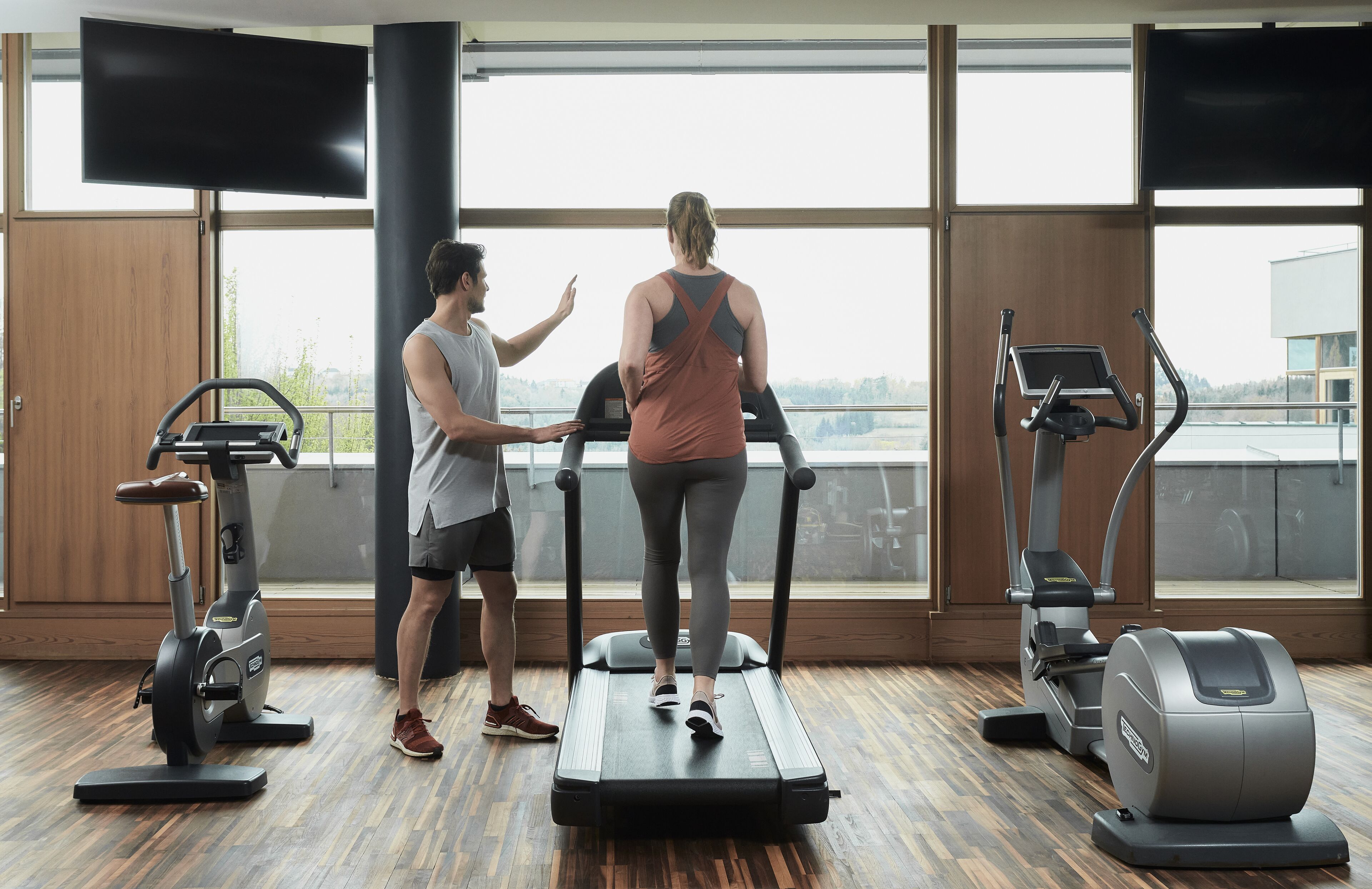 A gym with a treadmill, elliptical, and stationary bike.