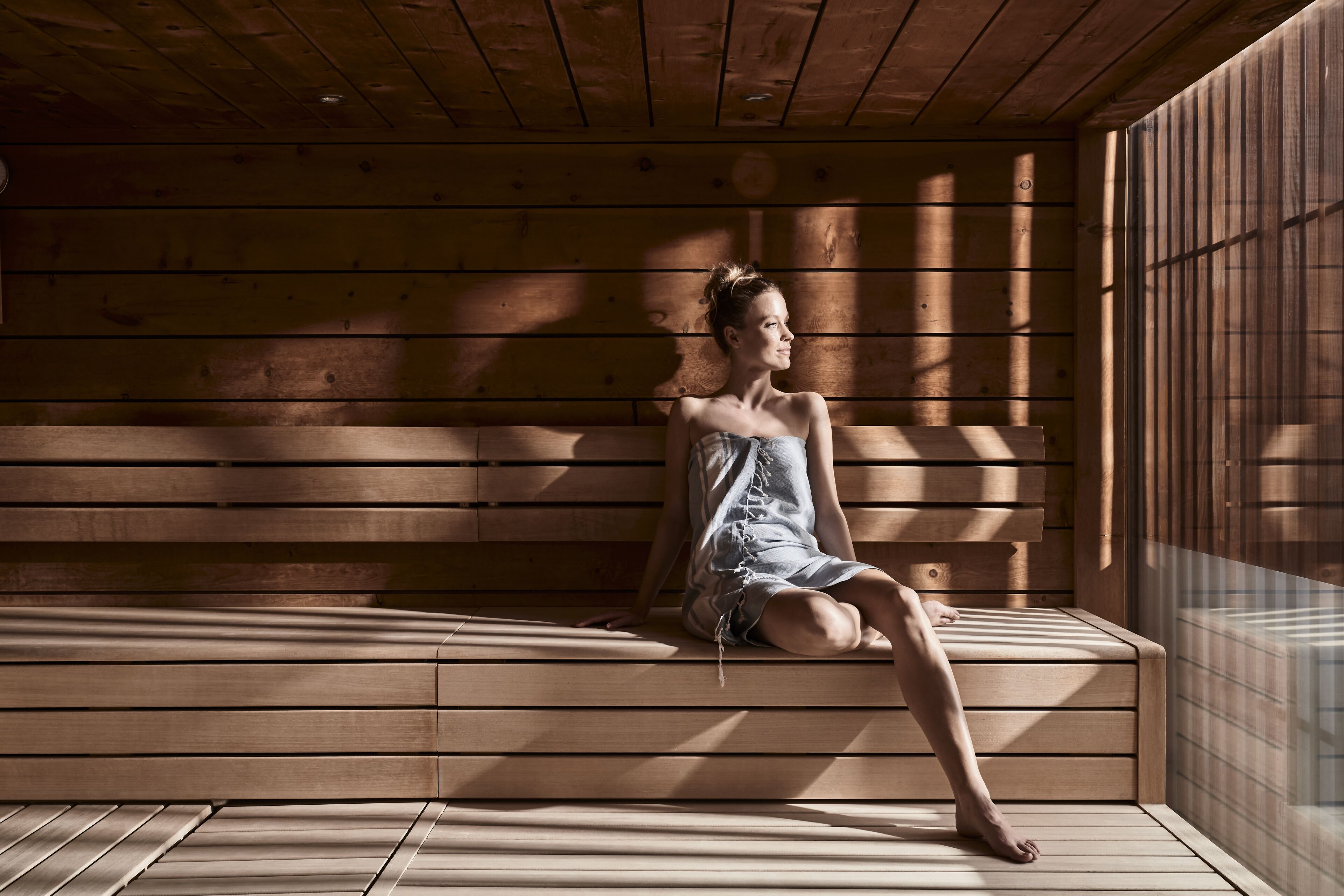 A wooden bench in a room with wooden walls and a window.