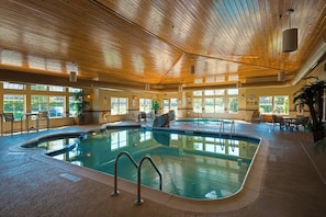 An indoor swimming pool with multiple lanes, surrounded by seating areas and windows. - Holiday Inn Express & Suites Chicago West-Roselle by IHG (Roselle)