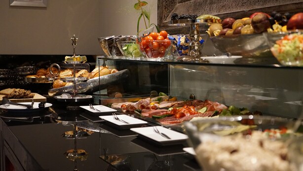 A buffet with various food items including fruits, vegetables, and meats. - Villahotel Rheinblick (Cologne)