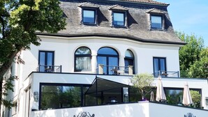 A two-story villa with a tiled roof, large windows, and balconies. The building has a sign for VillaHotel Rheinblick. - Villahotel Rheinblick (Cologne)